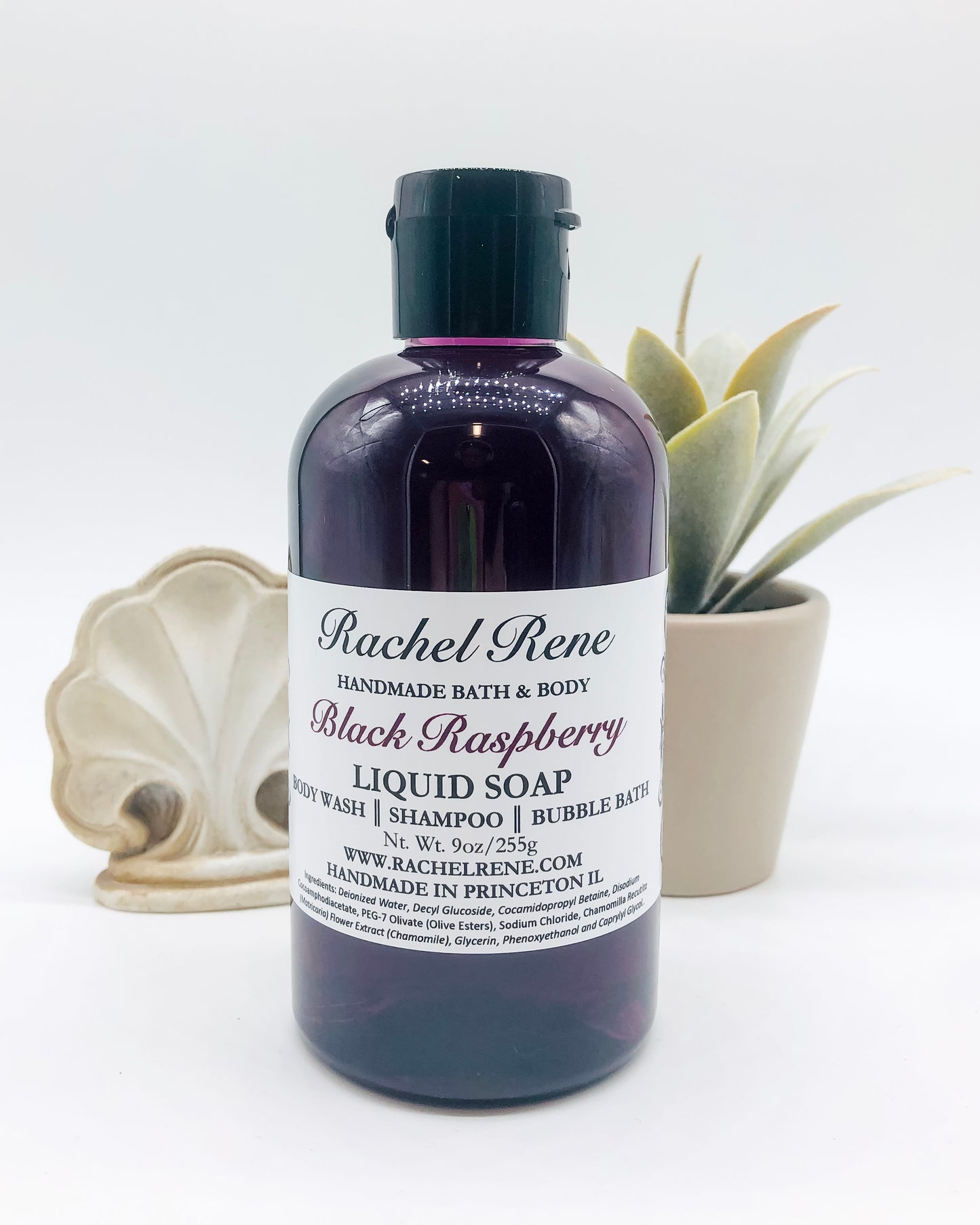 A purple liquid soap with a white label that reads "Rachel Rene: Handmade Bath & Body - Black Raspberry. Liquid Soap - Body Wash - Shampoo - Bubble Bath." It has a black pull top cap all in front of a white background.