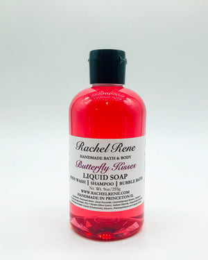 A semi-transparent pink liquid soap with a white label that reads "Butterfly Kisses." It has a black pull top cap and sits on a white background.