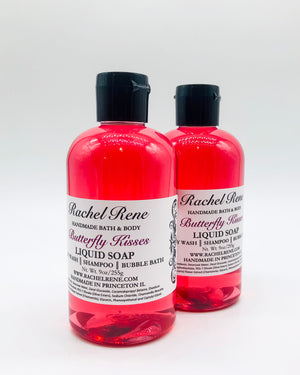 Two semi-transparent pink liquid soaps with a white label that reads "Butterfly Kisses." They have black pull top caps and sit on a white background.