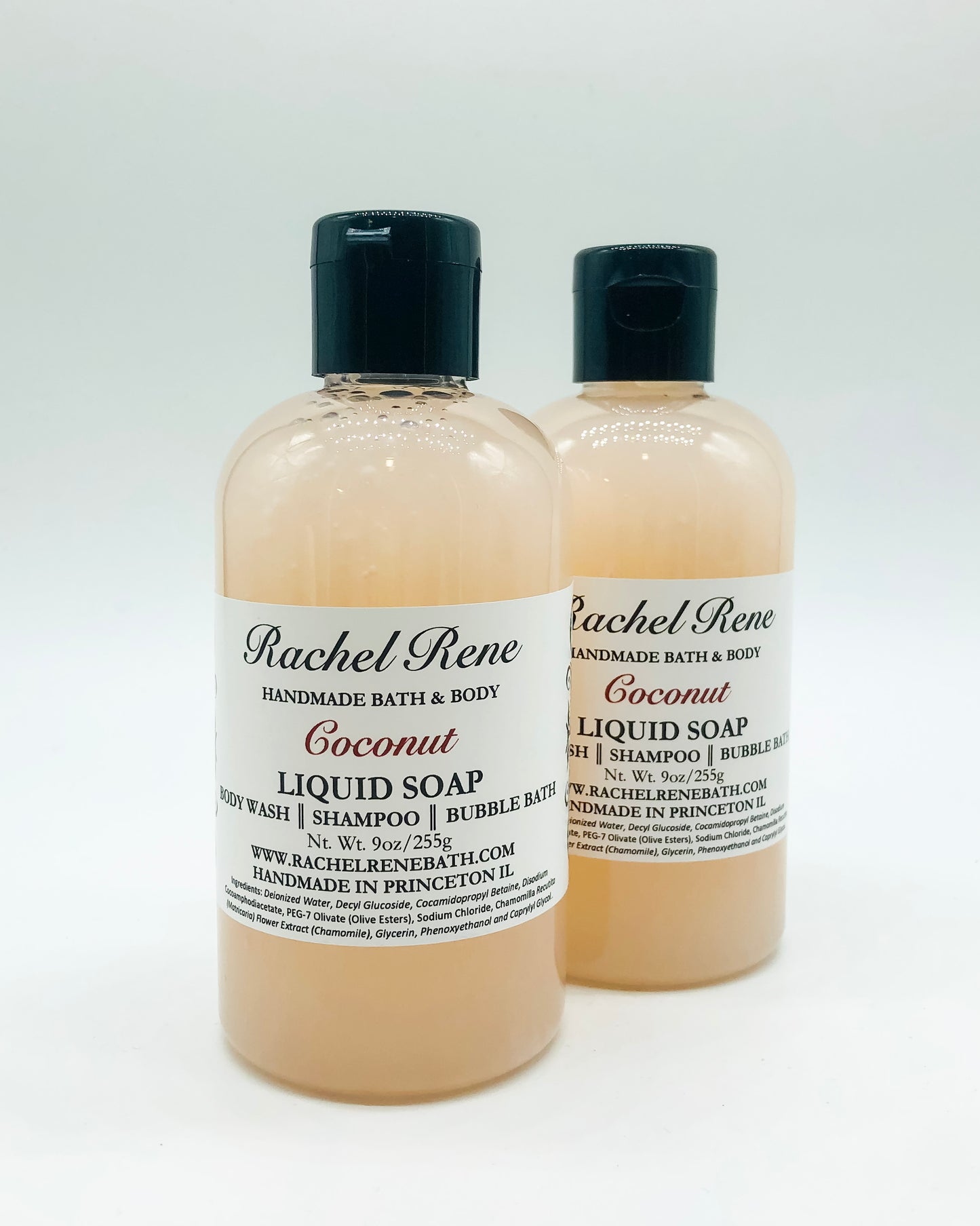 Two cloudy cream-colored liquid soaps with a white label that reads "Rachel Rene: Handmade Bath & Body - Coconut. Liquid Soap - Body Wash - Shampoo - Bubble Bath." They have a black pull top cap and sit on a white background.