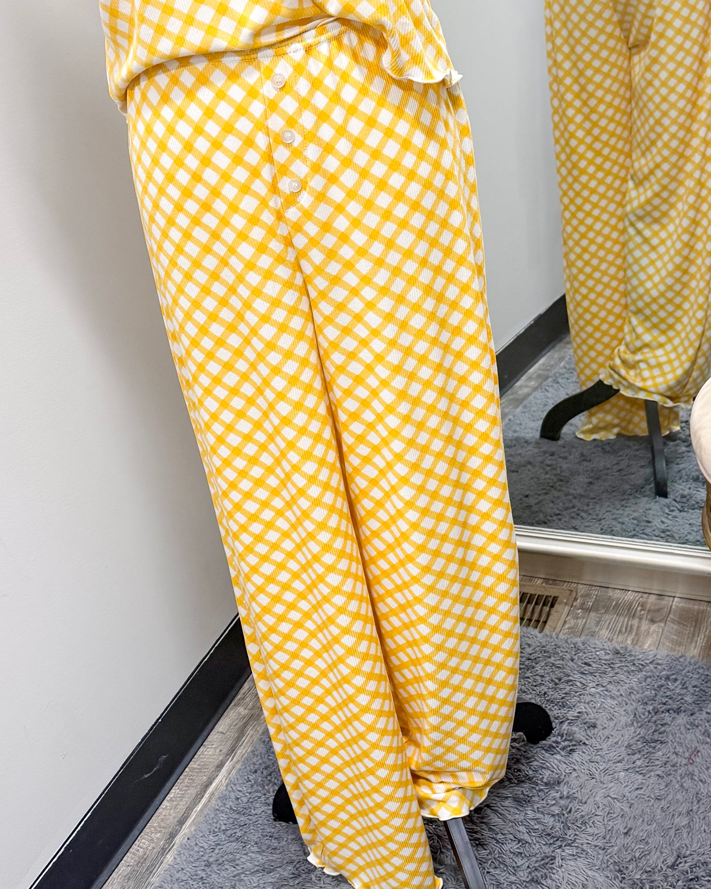 Yellow checkered pajama pants on a mannequin and reflected in a mirror.