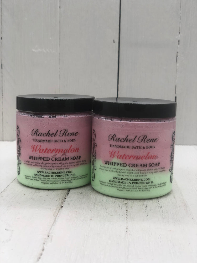 Watermelon scented whipped cream soap in a clear jar with a black lid the soap is colored green on the bottom half and a pinkish red on the top half 