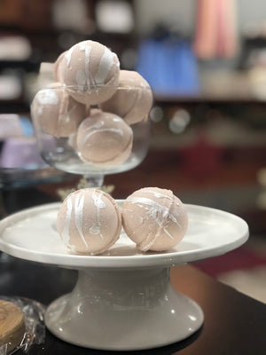 Brown bath bombs with white colorants splattered on top.