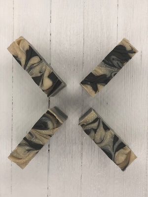 A khaki colored soap bar with dark brown swirls.