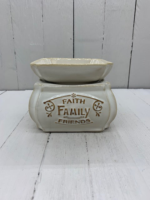 A ceramic wax warmer with the words "Faith, Family, Friends" written in gold on one side.