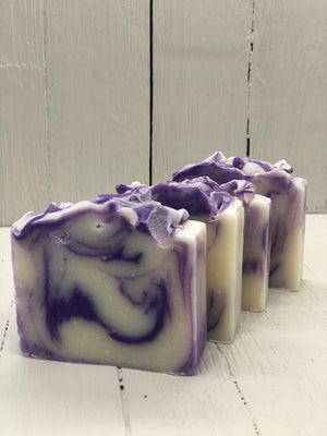 
            
                Load image into Gallery viewer, A white soap bar with purple swirls.
            
        