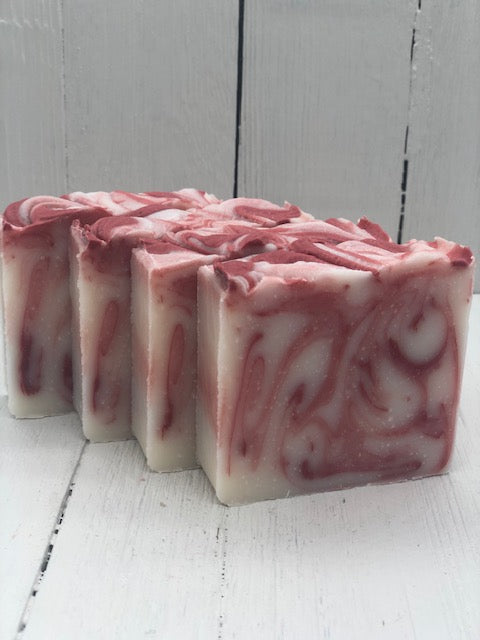 
            
                Load image into Gallery viewer, A white bar of soap with red swirls.
            
        