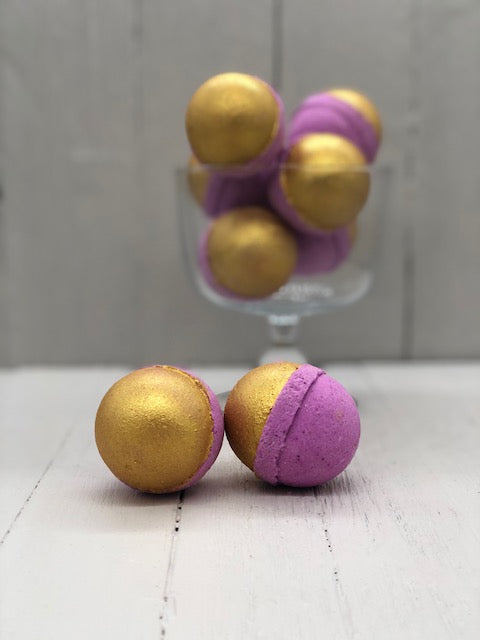 Purple bath bombs half-painted gold.