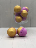 Purple bath bombs half-painted gold.