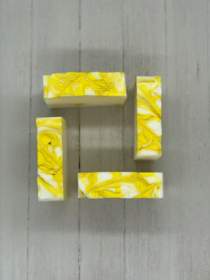 
            
                Load image into Gallery viewer, A white soap bar with yellow swirls.
            
        
